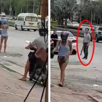 Wütender Autofahrer bedroht eine westliche Frau mit einem Baseball Schläger