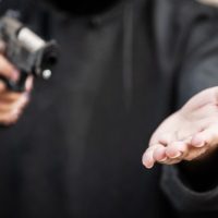 13-Jähriger Junge benutzt eine Pistole, um den Kunden eines Geschäfts auszurauben