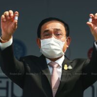 Premierminister Prayut Chan-o-cha hält zwei Fläschchen hoch