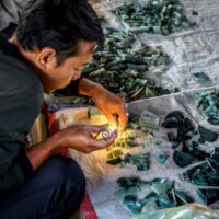 Ein Käufer prüft Edelsteine auf dem Jade- und Bernsteinmarkt in Mandalay