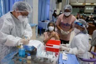 Eine Frau bereitet sich darauf vor, am 10. August 2021 in einer Schule in Pattani eine Dosis des AstraZeneca Covid-19-Coronavirus-Impfstoffs zu erhalten