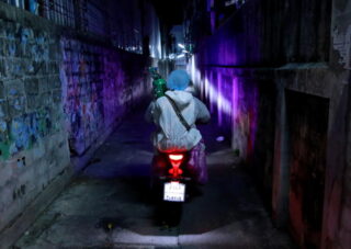Freiwillige reisen auf einem Motorrad, während sie am 5. August 2021 einen Sauerstofftank für einen Coronavirus-Patienten in Bangkok transportieren