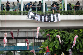 Bildnisse, die Menschen symbolisieren, die an Covid-19 gestorben sind, hängen von einem Skywalk über der Ratchaprasong Kreuzung,