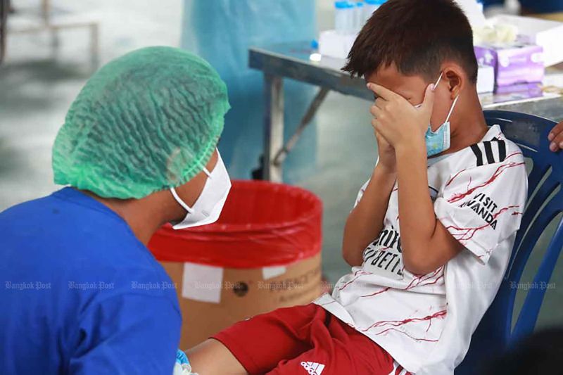 Der Junge reagiert, als ein Gesundheitspersonal ihn am vergangenen Samstag von einem Covid-19 Test im Bezirk Klong Toey in Bangkok überzeugen will