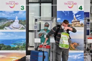 Ein internationaler Passagier reagiert, nachdem ein medizinischer Mitarbeiter ihm nach seiner Ankunft für das Tourismusprogramm „Phuket Sandbox“ einen Covid-19-Coronavirus-Abstrichtest gegeben hat,