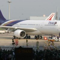 Mitarbeiter von Thai Airways International begrüßen am 8. April 2005 ein Airbus A340-Flugzeug am Flughafen Don Mueang