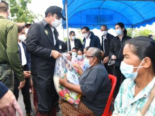 Premierminister Prayuth Chan o-cha begrüßt die Bewohner auf einem Lastwagen im Notfallkonvoi, der am Sonntag (26. September) durch eine überflutete Straße in Sukhothai fährt.