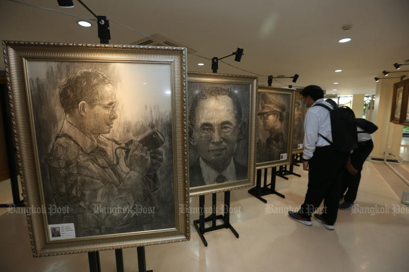 Besucher betrachten Gemälde Seiner Majestät König Bhumibol Adulyadej The Great in einer Ausstellung in der Zentralbibliothek des King Mongkut's Institute of Technology Ladkrabang am 9. März 2021