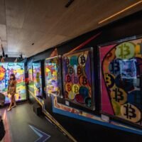 Besucher posieren für Fotos vor dem Kunstwerk Hold Onto Your Bitcoin von Gustav Szabo, auch bekannt als Szabotage, auf der Digital Art Fair Asia in Hongkong am 3. Oktober 2021