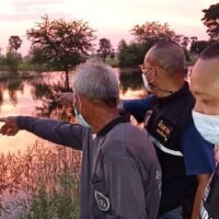 Ein Rettungshelfer und ein Anwohner zeigen auf einen Kanal im Bezirk Phimai, Nakhon Ratchasima,