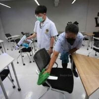 Mitarbeiter der Triamwitpattana-Schule im Bezirk Kannayao in Bangkok desinfizieren am Montag ein Klassenzimmer, um sich auf die Wiedereröffnung der Schule vorzubereiten