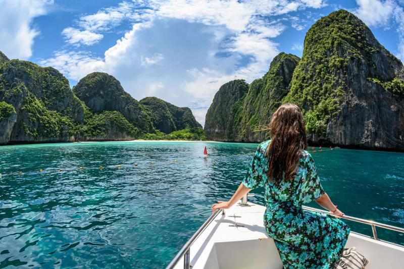 Tourist posiert für ein Foto auf einem Boot vor einer Grenzlinie, die vom thailändischen National Park, Wildlife and Plant Conservation Department festgelegt wurde,