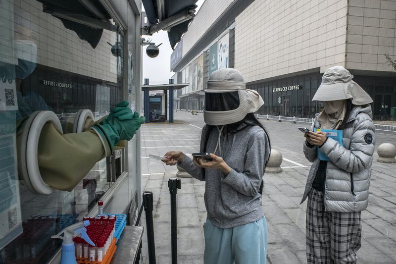 Anwohner stehen am Freitag für einen Covid-19 Test in Peking an. Die chinesischen Behörden schirmen die Stadt gegen wachsende Ausbrüche ab