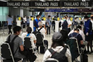 Ausländische Touristen bereiten ihre Dokumente am ersten Tag der Wiedereröffnung des Landes an den Einreisestraßen des Thailand Passes am Flughafen Suvarnabhumi vor