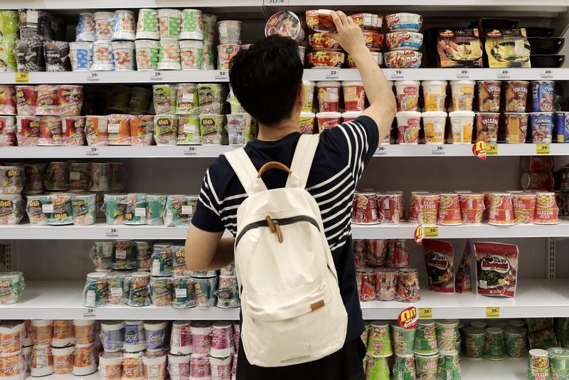 Ein Käufer kauft Instant Nudeln in einem Supermarkt.