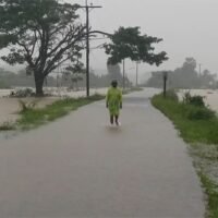 Ein Mann watet am Freitag durch eine überflutete Straße im Dorf Mamuang Song Ton im Bezirk Muang von Nakhon Si Thammarat.