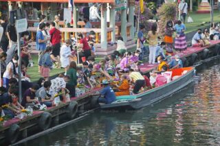 Gläubige stellen sich am Ufer eines Kanals auf dem schwimmenden Markt Kwan Riam in der Soi Serithai 60 in Min Buri auf