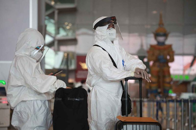 Reisende, die Schutzkleidung zur persönlichen Covid-19 Prävention tragen, checken am Montag für einen Flug am Flughafen Suvarnabhumi ein