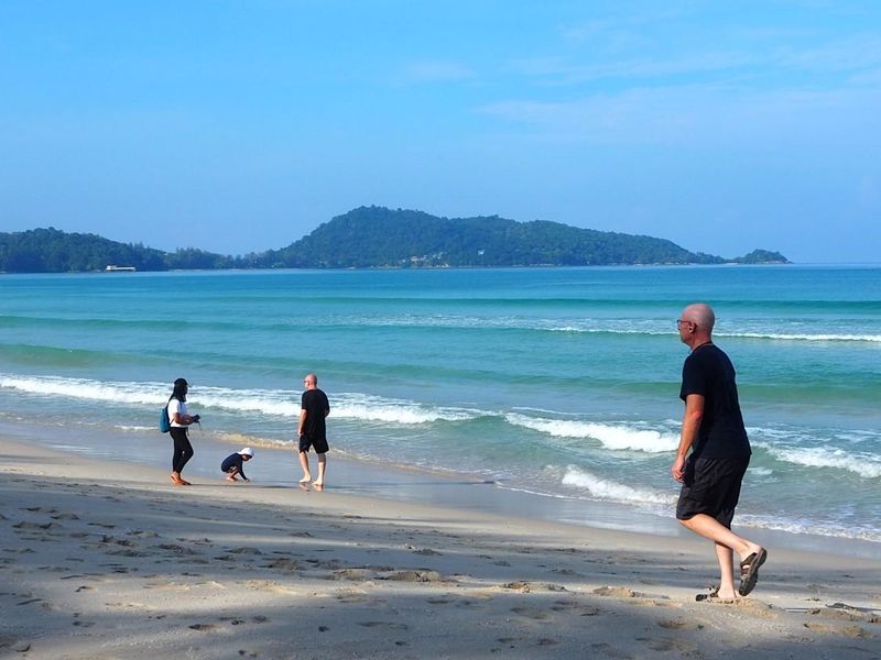 Touristen genießen einen Spaziergang am Strand von Patong in Phuket, da der Tourismus für die bevorstehende Hochsaison anzieht
