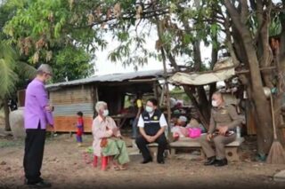 Der Gouverneur von Chaiyaphum, Kaisorn Kongchalard (rechts), spricht mit Großmutter Luan Choksiri (86) in der provisorischen Straßenunterkunft der Familie