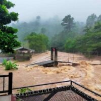 Der regengeschwollene Klong Thaha Kanal ergießt sich am Donnerstagmorgen über den Fußweg der Hängebrücke in der Gemeinde Khiriwong, im Bezirk Lan Saka von Nakhon Si Thammarat