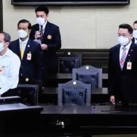 Die Co-Leiter des inzwischen aufgelösten People's Democratic Reform Committee erheben sich am Mittwoch vor dem Verfassungsgericht, das ihnen anordnet, ihren Status als Abgeordnete aufzugeben