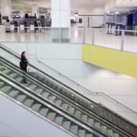 Ein Flugbesatzungsmitglied steht am 30. November dieses Jahres auf einer Rolltreppe im internationalen Terminal des Flughafens Sydney