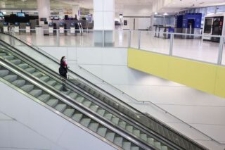 Ein Flugbesatzungsmitglied steht am 30. November dieses Jahres auf einer Rolltreppe im internationalen Terminal des Flughafens Sydney