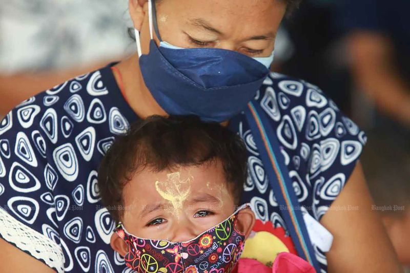 Eine Migrantin tröstet ihr weinendes Kind, während sie im Bang Phli Hospital in Samut Prakan auf einen Covid-19-Impfstoff wartet.