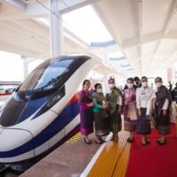 Frauen posieren am Donnerstag (2. Dezember) während einer buddhistischen Zeremonie im Bahnhof Vientiane neben einem Zug, einen Tag vor der Übergabezeremonie des Hochgeschwindigkeitsbahnprojekts