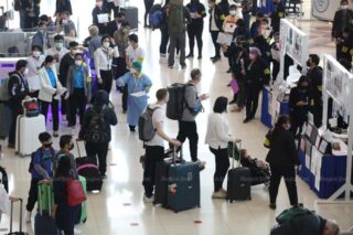 Internationale Passagiere warten bei ihrer Ankunft am Flughafen Suvarnabhumi am Montag auf Covid-19 Tests