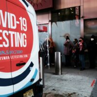 Menschen warten in langen Schlangen auf dem Times Square, um sich am Montag in New York City auf Covid-19 testen zu lassen