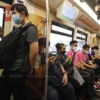 Pendler in einem elektrischen Zug tragen im Juli in Bangkok Gesichtsmasken, um sich vor Covid-19 zu schützen.