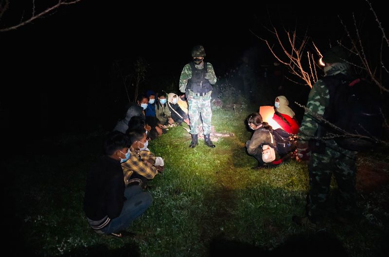 Soldaten sprechen mit einer Gruppe von Arbeitssuchenden aus Myanmar und zwei Guides, die am Samstag kurz vor Sonnenaufgang im Bezirk Fang in Chiang Mai bei der illegalen Einreise erwischt wurden