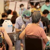 Angehörige der Gesundheitsberufe impfen Menschen am Mittwoch im Einkaufszentrum Asiatique The Riverfront im Stadtteil Bang Kholaem in Bangkok gegen Covid-19