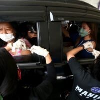Die Bewohner erhalten am Donnerstag Pfizer – BioNtech Auffrischungsimpfungen an einer Drive-Through Covid-19 Impfstelle in Manila.