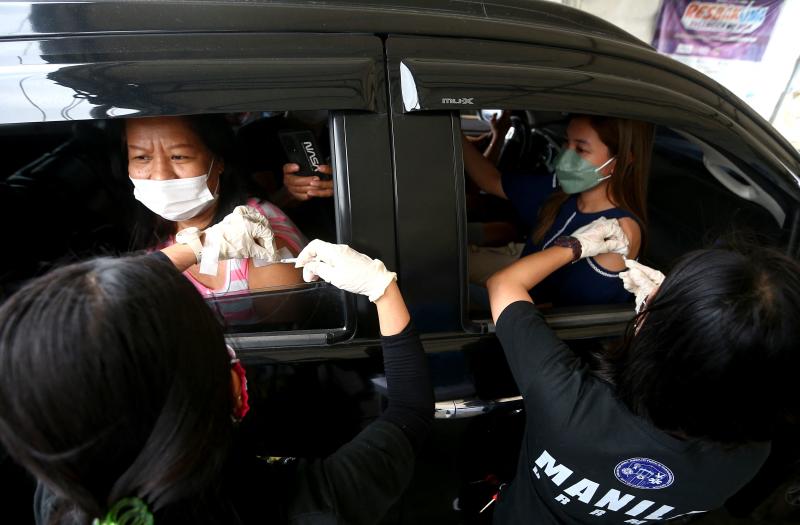 Die Bewohner erhalten am Donnerstag Pfizer – BioNtech Auffrischungsimpfungen an einer Drive-Through Covid-19 Impfstelle in Manila.