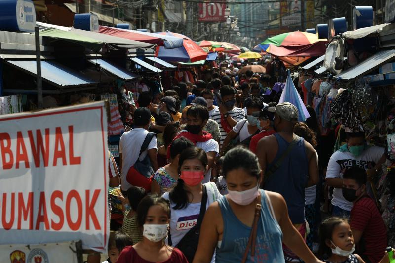 Dieses am 30. November 2021 aufgenommene Foto zeigt Menschen, die sich auf einem Straßenmarkt drängen, um vor den Weihnachtsferien in einem beliebten Einkaufszentrum in Manila einzukaufen