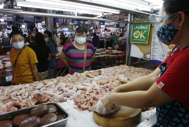 Ein Verkäufer bereitet Hühnerfleisch für Kunden auf dem Ying Charoen Market in Bangkok zu.