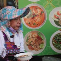Ein Verkäufer isst am Sonntag entlang der Chakraphet Road in Bangkok. Viele Menschen klagen jetzt über die hohen Lebenshaltungskosten.