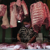 Ein Verkäufer verkauft am 13. Januar 2022 auf einem Markt in Yaowarat Schweinefleisch