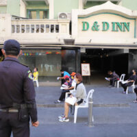 Ein „Thetsakit“-Inspektor der Stadt Bangkok überwacht Büro- und Ladenmitarbeiter in der Khao San Road, die am Donnerstag auf Covid-19 Tests warten