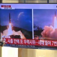 Eine Frau geht am 30. Januar 2022 auf einem Bahnhof in Seoul an einer Nachrichtensendung mit Aufnahmen eines nordkoreanischen Raketentests vorbei.