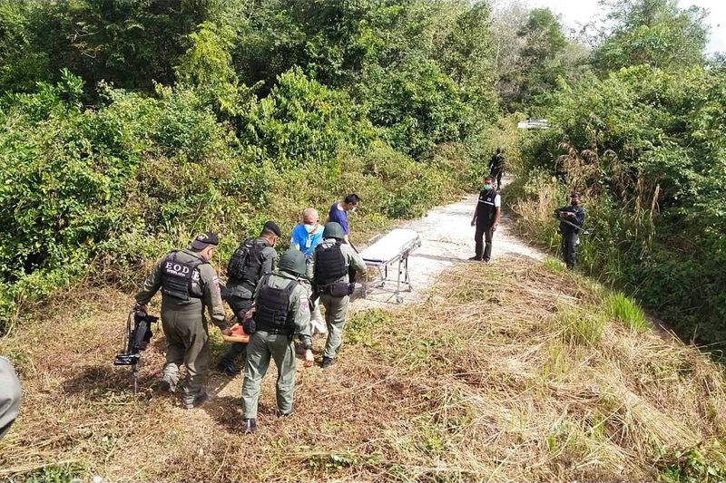 Beamte der Sprengstoffräumung tragen die beiden verletzten Mitglieder ihres Trupps am Freitagmorgen vom Ort der Explosion im Chana-Distrikt, Songkhla,