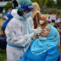 Beamte des öffentlichen Gesundheitswesens führen Tests an Lehrern und Schülern durch, um eine Infektion mit dem Covid-19 Virus am ersten Schultag zu verhindern