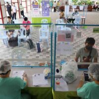 Covid-19-Patienten betreten am 16. Februar ein kommunales Isolationszentrum im Wat Saphan im Bezirk Klong Toey in Bangkok.