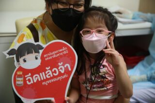 Ein Mädchen gibt am Montag ein Victory Zeichen, nachdem es im Queen Sirikit National Institute of Child Health in Bangkok eine Pfizer Spritze erhalten hat
