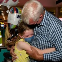 Ein Mann umarmt seine Enkelin bei der Ankunft am internationalen Flughafen von Sydney, während Australien seine Grenzen wieder öffnet.