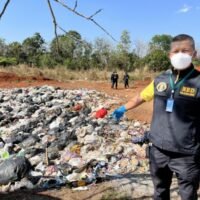 Ein Polizist zeigt einen illegalen Müllhaufen, der in einem Waldreservat in Lampangs Bezirk Mae Tha gefunden wurde. KÖNIGLICHE THAIISCHE POLIZEI