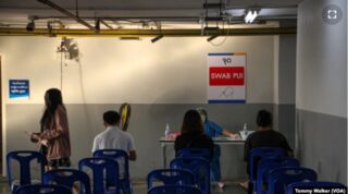 Ein medizinischer Mitarbeiter stellt Patienten im Thonburi Bamrungmaung Hospital, Bangkok, Thailand, 24. Februar 2022, ein COVID-19-Testkit zur Verfügung.